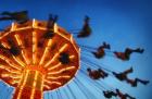 Adults Riding a Carnival Swing Game