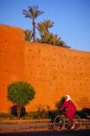 Veiled Woman Bicycling Below Red City Walls, Marrakech, Morocco