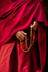Hands of a monk in red holding prayer beads, Leh, Ladakh, India