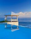 Gazebo reflecting on pool with sea in background, Long Island, Bahamas