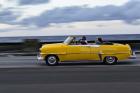 1950's era car in motion along the Malecon or seawall, Havana, Cuba