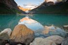 Rocky Mountains and boulders reflected in Lake Louise, Banff National Park, Alberta, Canada