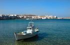 Mykonos, Greece Boat off the island with view of the city behind