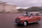 Cab racing past Buckingham Palace, London, England