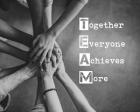 Together Everyone Achieves More - Stacking Hands Grayscale