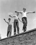 1950s Three Laughing Boys Walking On Top Of Stone Wall