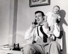 1950s Father Holding Baby While On The Phone