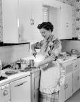 1950s Housewife In Kitchen Mixing Ingredients