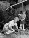 1960s Boy Helping Grandmother Plant Flowers