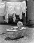 1930s 1940s Girl Outdoors Sitting In Laundry Basket