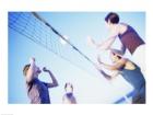 Low angle view of two young couples playing beach volleyball