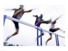Low angle view of three men jumping over a hurdle