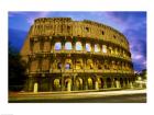 Low angle view of the old ruins of an amphitheater lit up at dusk, Colosseum, Rome, Italy