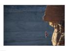 Man hanging from a rope on the edge of a cliff