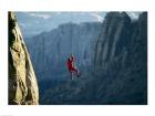 Rear view of a man rappelling down a rock