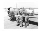 Rear view of four soldiers standing near a fighter plane, T-6 Texan