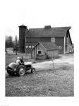 Man with a Boy Riding a Tractor in a Field