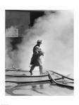 Firefighter walking in front of smoke