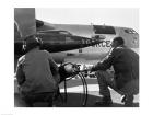 Rear view of two men crouching near fighter planes, X-15 Rocket Research Airplane, B-52 Mothership