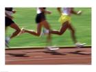 Low section view of male athletes running on a running track