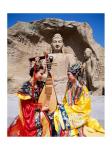 Two girls in traditional costumes in front of the Buddha Statue, China