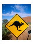 Kangaroo sign on a road with a rock formation in the background, Ayers Rock