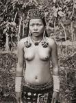 A Kenyah woman from Sarawak, Borneo, Malaysia, with distended ear lobes. The ear lobes are pierced at an early age and when the hole is sufficiently large a copper ring is inserted and eventually others are added until the the lobe reaches to below the co