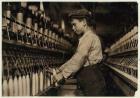 A doffer replaces full bobbins at Globe Cotton Mill, Augusta, Georgia, 1909 (b/w photo)