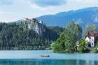 Lake Bled, Upper Carniola, Slovenia. Bled Castle seen across the lake. Couple enjoying outing in rowing boat.