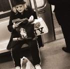 Woman reading on a subway with a Marilyn Monroe purse and an 'I Love New York' bag, 2004 (b/w photo)