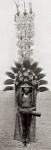 A head dress worn by a member of the Roro tribe from Papua New Guinea, Melanesia. The design of the tall framed feather structure on the head is unique to each clan, not to be imitated by other clans. After a 19th century photograph. From Customs of The W