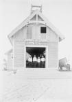 Kill Devil Hills Lifesaving Station, with four crew members standing in the doorway, with the lifesaving boats. Kitty Hawk in North Carolina, USA, 1902