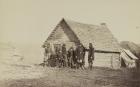 A group of soldiers, and two young men, one an African American, stand outside of log cabin quarters, 1861-65 (b/w photo)