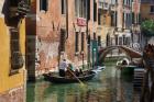 Venice, Italy. Tourists enjoying gondola ride on canal. (photo)
