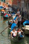 Venice, Venice Province, Veneto, Italy. Tourists enjoying gondola ride on canal.