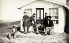 Five Civil War soldiers gathered on dirt porch outside home, African American youth seated near them, 1861-65 (b/w photo)