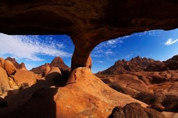 Boy under natural rock arch at Spitzkoppe, Namibia | Obraz na stenu