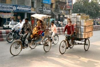 People and cargo move through streets via rickshaw, Varanasi, India | Obraz na stenu
