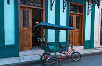 Cuba, Camaquey, bike carriage and buildings | Obraz na stenu