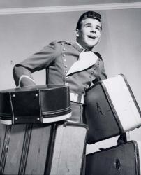 1950s Smiling Bellboy Carrying Four Bags Of Luggage | Obraz na stenu