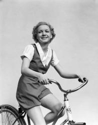1930s Smiling Blonde Woman Riding Bicycle | Obraz na stenu
