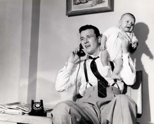 1950s Father Holding Baby While On The Phone | Obraz na stenu