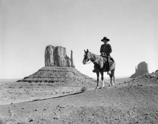 Navajo Indian In Cowboy Hat On Horseback With Monument Valley Rock Formations In Background | Obraz na stenu