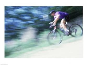 Side profile of a young man riding a bicycle | Obraz na stenu