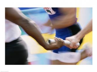 Mid section view of runners exchanging baton at a relay race | Obraz na stenu