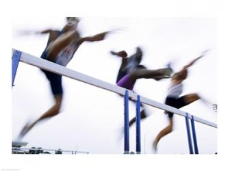 Low angle view of three men jumping over a hurdle | Obraz na stenu