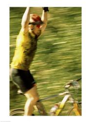 Young man sitting on a bicycle with his arms raised | Obraz na stenu