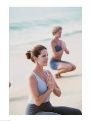 Young woman and a mid adult woman meditating on the beach | Obraz na stenu