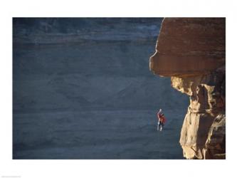 Man hanging from a rope on the edge of a cliff | Obraz na stenu