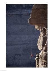 Man hanging from a rope on the edge of a cliff | Obraz na stenu